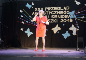 Zdjęcie uczestniczki występującej na scenie podczas XXII Przeglądu Artystycznego Ruchu Seniora 2019