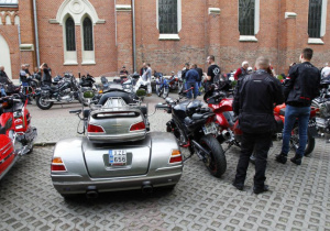 Zdjęcie uczestników oraz motocykli stojących przed kościołem pw. Niepokalanego Poczęcia NMP w Koluszkach podczas mszy świętej