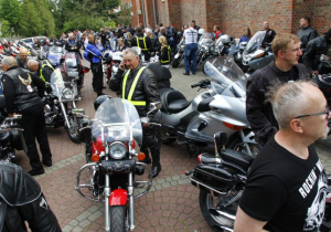 Zdjęcie uczestników oraz motocykli stojących przed kościołem pw. Niepokalanego Poczęcia NMP w Koluszkach po mszy świętej