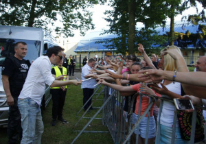 Zdjęcie wokalisty Zespołu After Party rozdającego fanom autografy przy scenie Amfiteatru Parku Miejskiego