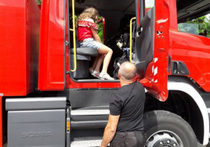 Zdjęcie uczestników III turnusu "Wakacji w mieście" podczas oglądania wozu stażackiego na parkingu MOK