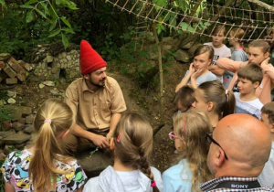 Zdjęcie Skrzatologa oraz uczestników wycieczki do Doliny Skrzatów we Florentynowie podczas zwiedzania obiektu