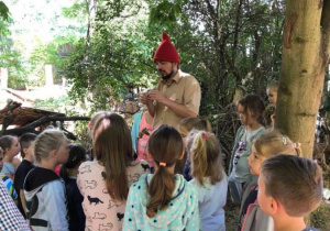 Zdjęcie Skrzatologa oraz uczestników wycieczki do Doliny Skrzatów we Florentynowie podczas zwiedzania obiektu