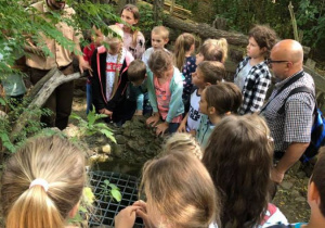 Zdjęcie Skrzatologa oraz uczestników wycieczki do Doliny Skrzatów we Florentynowie podczas zwiedzania obiektu