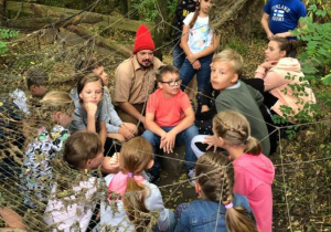 Zdjęcie Skrzatologa oraz uczestników wycieczki do Doliny Skrzatów we Florentynowie podczas zwiedzania obiektu