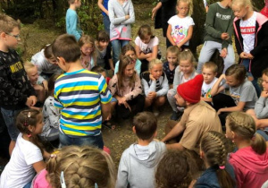 Zdjęcie Skrzatologa oraz uczestników wycieczki do Doliny Skrzatów we Florentynowie podczas zwiedzania obiektu