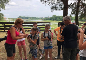 Zdjęcie pani instruktor oraz uczestników warsztatów fotograficznych w Przedborskim Parku Krajobrazowym w ramach 7 Kolorowej Lokomotywy