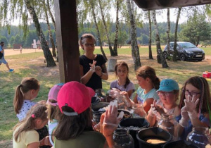 Zdjęcie pani instruktor oraz uczestników warsztatów rękodzielniczych w Przedborskim Parku Krajobrazowym w ramach 7 Kolorowej Lokomotywy