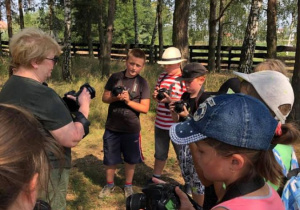 Zdjęcie pani instruktor oraz uczestników warsztatów fotograficznych w Przedborskim Parku Krajobrazowym w ramach 7 Kolorowej Lokomotywy