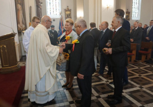 Zdjęcie przedstawicieli władz Gminy Koluszki oraz Starostów Dożynek 2019 składających dary dożynkowe na ręce księdza proboszcza podczas Mszy Świętej w Kościele pw. Niepokalanego Poczęcia NMP w Koluszkach