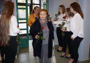 Zdjęcie uczennic Zespołu Szkół nr 2 w Koluszkach wręczających kwiaty zaproszonym gościom przed Galą z okazji Święta Edukacji Narodowej