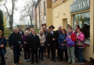 Zdjęcie słuchaczy Uniwersytetu Trzeciego Wieku Politechniki Łódzkiej oraz Mateusza Jaśkieiwcza przed Salą Muzealną MOK