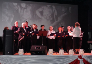 Zdjęcie wystepujących na scenie podczas koncertu patriotycznego pt. Tobie Ojczyzno w Miejskim Ośrodku Kultury w Koluszkach