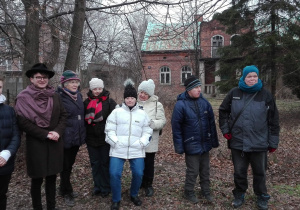 Zdjęcie członków Polskiego Stowarzyszenia na rzecz Osób z Niepełnosprawnością Intelektualną koło w Zgierzu oraz Matesza Jaśkiewicza przed dawnym domem Władysława Strzemińskiego oraz Katarzyny Kobro