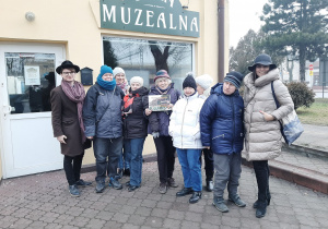 Zdjęcie członków Polskiego Stowarzyszenia na rzecz Osób z Niepełnosprawnością Intelektualną koło w Zgierzu oraz Matesza Jaśkiewicza przed Salą Muzealną MOK