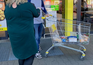 Zdjęcie Dyrektor MOK Elżbiety Przywara wręczającej maseczkę ochronną mężczyźnie