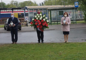 Zdjęcie przedstawicieli Gminy Koluszki przygotowanych do złożenia kwiatów pod pomnikiem Orła Białego