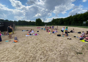 Zdjęcie uczestników pierwszego turnusu Wakacji w Mieście 2021 podczas odpoczynku na plaży przy basenie w Lisowicach