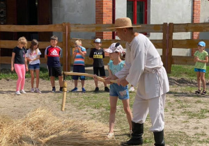 Zdjęcie przedstawia dzieci podczas warsztatów "Od ziarenka do bochenka" w Zagrodzie Edukacyjnej Konarzew Stajnia Lusi.