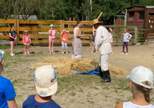 Zdjęcie przedstawia dzieci podczas warsztatów "Od ziarenka do bochenka" w Zagrodzie Edukacyjnej Konarzew Stajnia Lusi.