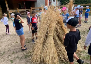 Zdjęcie przedstawia dzieci podczas warsztatów "Od ziarenka do bochenka" w Zagrodzie Edukacyjnej Konarzew Stajnia Lusi.