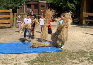 Zdjęcie przedstawia dzieci podczas warsztatów "Od ziarenka do bochenka" w Zagrodzie Edukacyjnej Konarzew Stajnia Lusi.