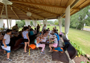 Zdjęcie przedstawia uczestników I turnusu Wakacji w mieście podczas zajęc plastycznych. Dzieci wykonują maski oraz kolorują obrazki ze zwierzętami