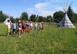 Zdjęcie przedstawia uczestników II turnusu Wakacji w mieście podczas warsztatów w wiosce indiańskiej TATANKA