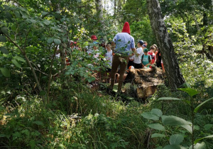 Zdjęcie Skrzatologa oraz uczestników wycieczki do Doliny Skrzatów w Chociszewie podczas zwiedzania obiektu