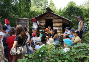 Zdjęcie Skrzatologa oraz uczestników wycieczki do Doliny Skrzatów w Chociszewie podczas zwiedzania obiektu