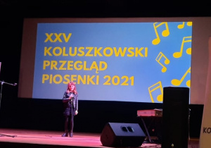 Zdjęcie przedstawia uczestniczkę XXV Koluszkowskiego Przeglądu Piosenki podczas występu na scenie