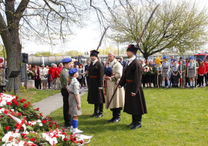 Zdjęcie delegacji składającej kwiaty podczas Uroczystych Obchodów 231 Rocznicy Uchwalenia Konstytucji 3 Maja przy Pomniku Orła Białego w Koluszkach