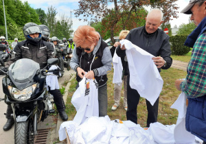 Zdjęcie motocyklistów oraz organizatorów wręczających pamiatkowe koluszki podczas IX Koluszkowskiego Zlotu Motocyklowego