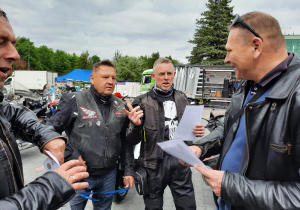 Zdjęcie Burmistrza Koluszek wręczającego podziękowania za udział uczesnikom IX Koluszkowskiego Zlotu Motocyklowego na parkingu przed Urzędem Miejskim w Koluszkach