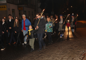 Zdjęcie przedstawia uczestników przemarszu udających się na Apel Poległych na Cmenatrzu Rzymskokatolickim w Koluszkach