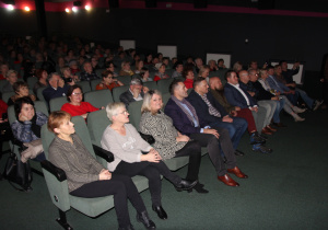 Zdjęcie przedstawia uczestników spotkania podróżniczego z legendarną podróżniczką Elżbietą Dzikowską w sali widowiskowej MOK